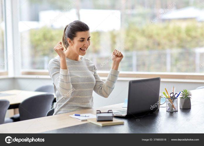 happy woman with laptop working at home office